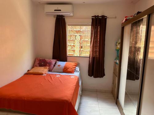 um pequeno quarto com uma cama e uma janela em Casa chácara para alugar no período do festival de Parintins em Parintins