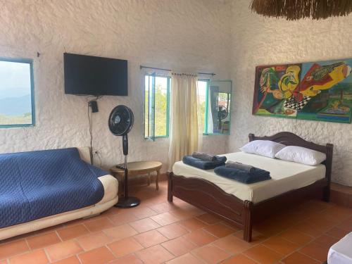 a bedroom with two beds and a fan in it at Hotel La Reserva in San Gil