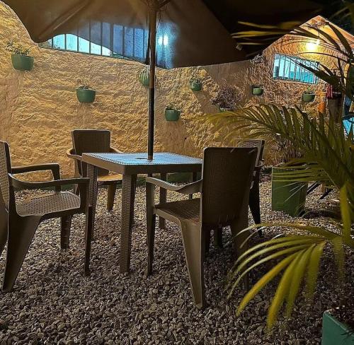 een tafel met stoelen en een parasol in een patio bij Hotel La Reserva in San Gil
