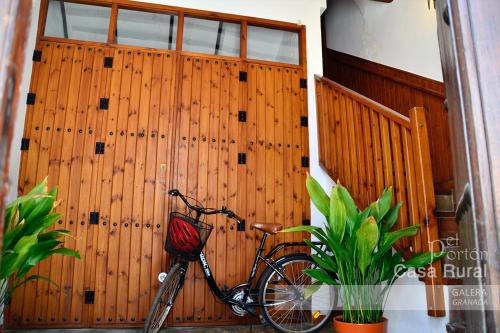 uma bicicleta estacionada em frente a uma porta de madeira em Casa Rural El Portón de Galera em Galera