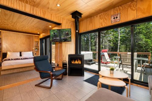 1 dormitorio con 1 cama y chimenea en una habitación en Les Refuges du Massif de Charlevoix en Petite-Rivière-Saint-François