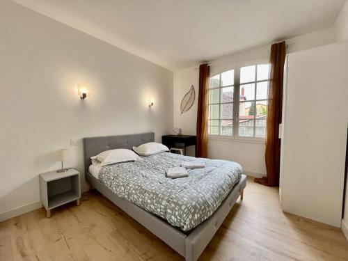 ein Schlafzimmer mit einem Bett und einem großen Fenster in der Unterkunft Cosy Appartement Montferrand tout équipé 6prs 27 Languedoc in Clermont-Ferrand