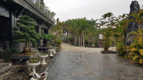 a cobblestone street with toilets and palm trees at Khu nghỉ dưỡng GOOD TIME in Ban Hin Lom