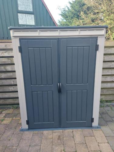 a pair of garage doors in front of a house at Cappuccetto Rosso in Nieuwe-Niedorp