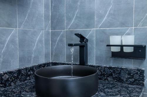 a bathroom with a sink with a water fountain at Malixa Lofts in Wakiso