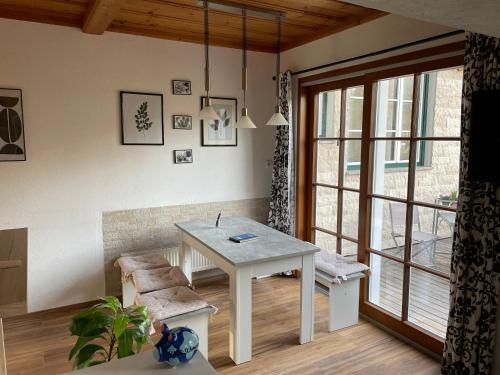 ein Wohnzimmer mit einem weißen Tisch und einem Fenster in der Unterkunft Haus Frey in Altaussee