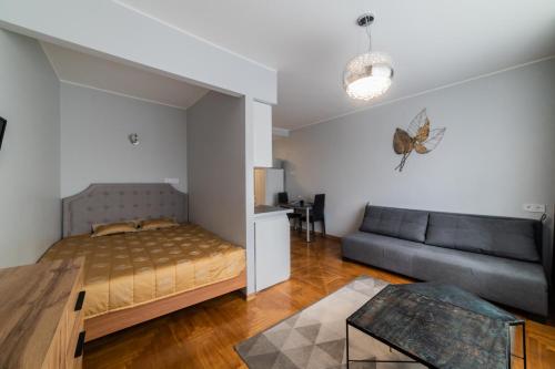 a bedroom with a bed and a couch at Fox studio apartment in Šiauliai