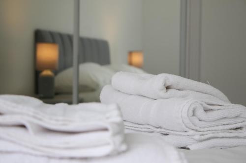 a stack of towels sitting on a counter in a bathroom at Merchant City Apartment in Glasgow