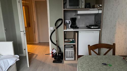 um quarto com uma cozinha com uma mesa e um micro-ondas em Rum för övernattning em Trollhättan
