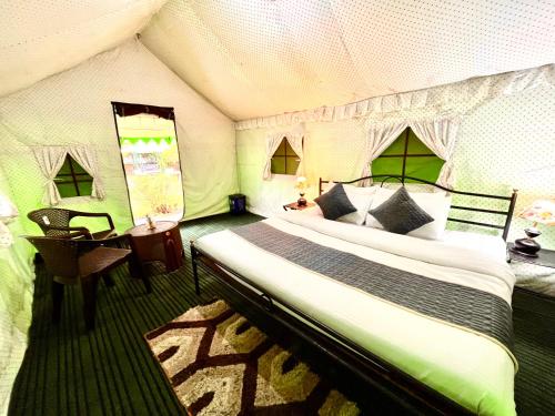 a bedroom with a bed and a desk in a tent at The Himalayan Cottage Camping With Bonfire, Manali - Riverside in Manāli