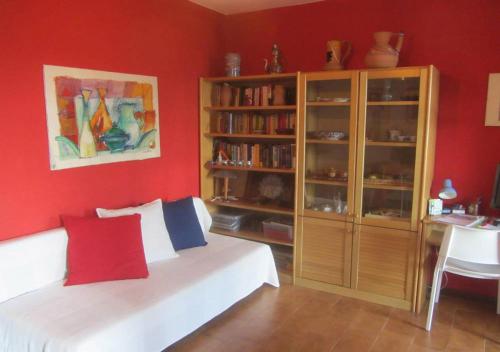ein rotes Zimmer mit einem Bett und einem Bücherregal in der Unterkunft IL BALCONE SUL LAGO in Magreglio