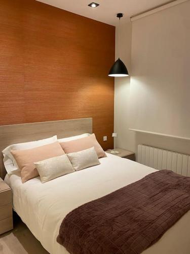a bedroom with a large white bed with pink pillows at Apartamento en San Mames in Bilbao