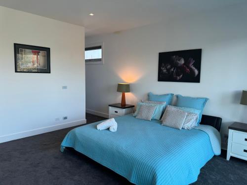a bedroom with a blue bed in a room at Geelong Beach Q House in North Shore