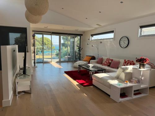 a living room with a couch and a table at Geelong Beach Q House in North Shore