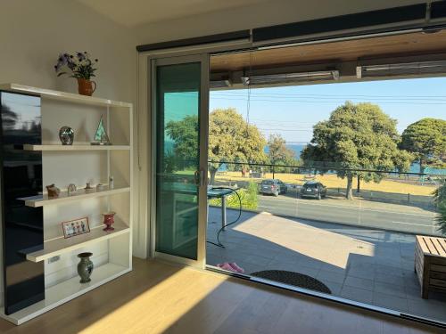 a room with a large glass door with a view of a street at Geelong Beach Q House in North Shore
