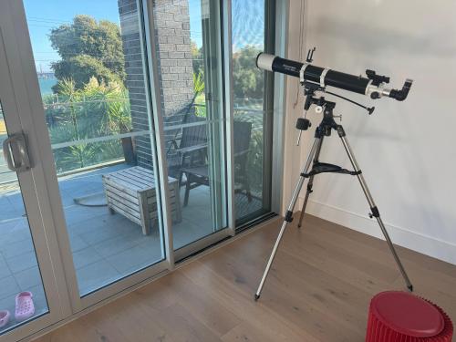 a camera on a tripod in a room with a window at Geelong Beach Q House in North Shore