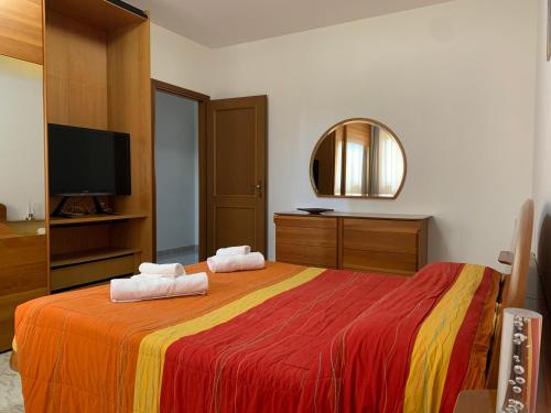 a bedroom with a large bed with two towels at A casa di Zia Ale in Brindisi