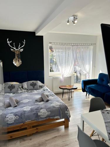 a bedroom with a bed with a blue headboard at Pokoje i apartamenty Wierchy Zakopane in Zakopane