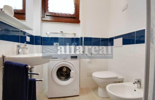 ein Badezimmer mit einem Waschbecken und einer Waschmaschine in der Unterkunft Elba in Castiglione della Pescaia