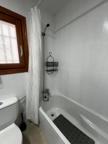un bagno bianco con vasca e WC di Apartamento 70 Vera Playa a Vera