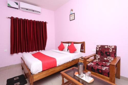 um quarto com uma cama e uma cadeira em OYO Sambit Nx em Bhubaneshwar