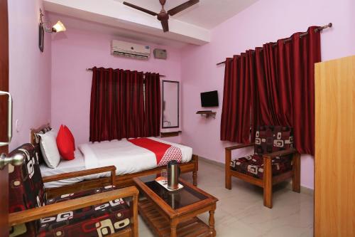 um quarto com uma cama e uma cadeira num quarto em OYO Sambit Nx em Bhubaneshwar