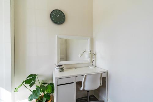 a white desk with a mirror and a chair at Dublin Airport Homestay in Dublin