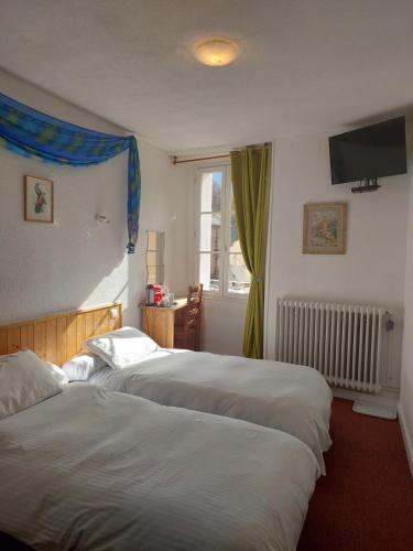 a hotel room with two beds and a window at La Fontaine - Chambres d'Hôtes in Olette
