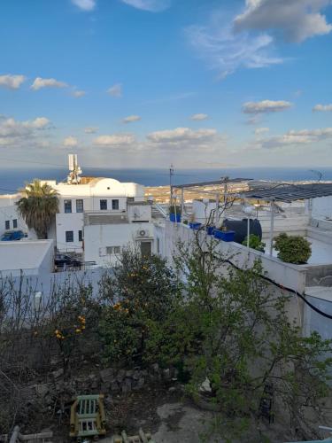 a view of a white building with the ocean in the background at SPILIOTICA CENTRAL APARTMENTS in Fira