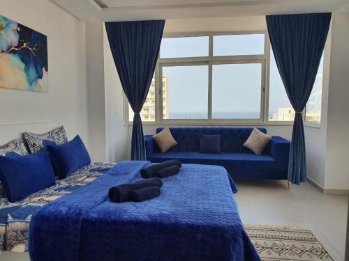 a blue bedroom with two beds and a blue couch at Stunning Penthouse with Sea and Castle View (2BDR) in Sousse