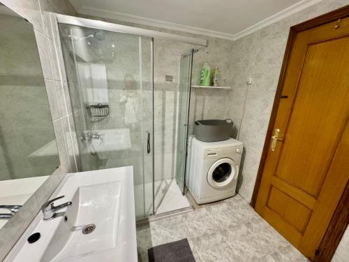 a bathroom with a shower and a washing machine at Your Long Stay Attic Home in Valencia in Valencia