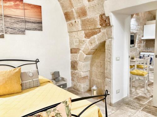 a bedroom with a bed and a stone fireplace at Antica Pietra in Polignano a Mare