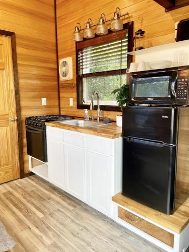a kitchen with a sink and a stove and a microwave at Evergreen in Waldport