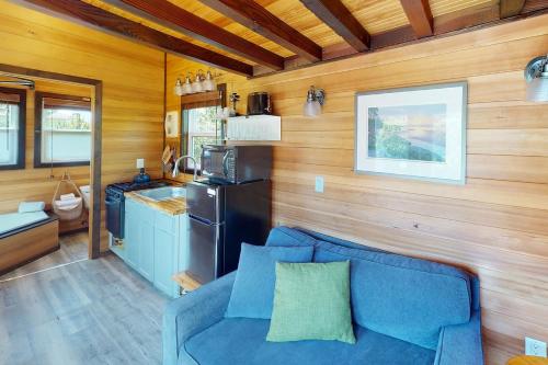 een woonkamer met een blauwe bank en een keuken bij Evergreen in Waldport