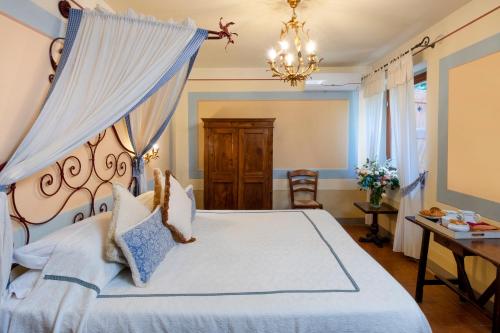 una camera con letto e lampadario a braccio di Locanda Del Molino a Cortona