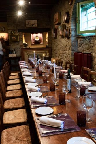 a long table with white plates and wine glasses at Locanda Del Molino in Cortona