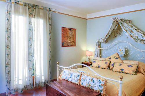 a bedroom with a white bed with a canopy at Locanda Del Molino in Cortona
