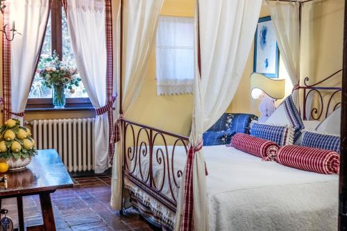 a bedroom with a bed and a table and a window at Locanda Del Molino in Cortona