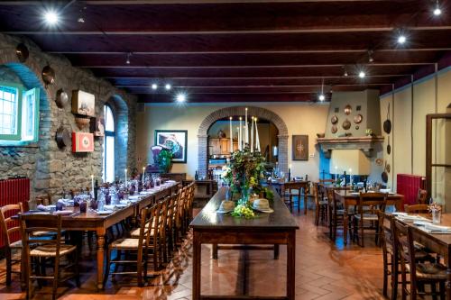 a restaurant with wooden tables and chairs and a stone wall at Locanda Del Molino in Cortona