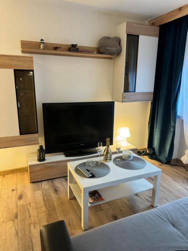 魯達希隆斯卡的住宿－Mieszkanko W Sam Raz，客厅配有电视和白色桌子。