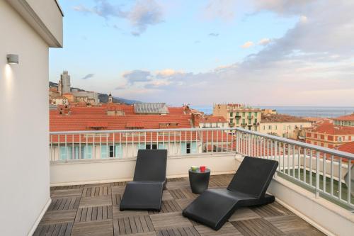 a balcony with two chairs and a view of the city at Ibis Styles Menton Centre in Menton