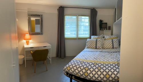 a bedroom with a bed and a desk and a window at BB 2 chambres en maison 15 minutes centre de Paris in Asnières-sur-Seine