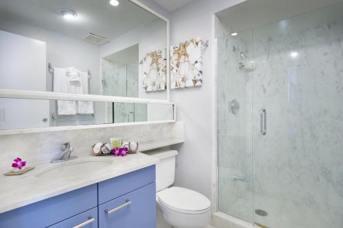 a bathroom with a shower and a toilet and a sink at Aston at The Whaler on Kaanapali Beach in Lahaina