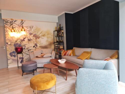 a living room with a couch and chairs and a table at Lazy Olives in Tongeren