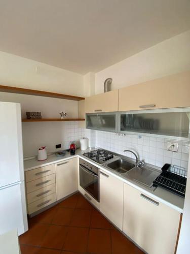 una cocina con armarios blancos y fregadero en Welcome to Lallaby's Home en Scandicci
