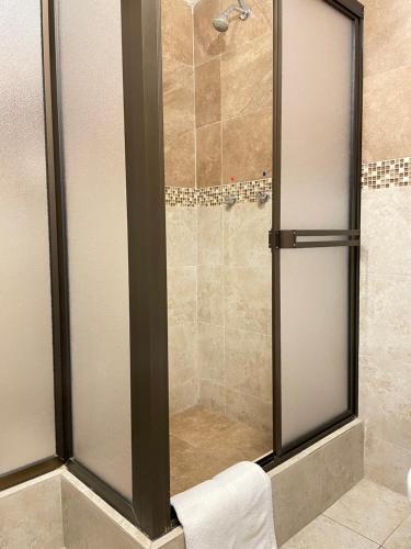 um chuveiro com uma porta de vidro na casa de banho em Loft NASS Atahualpa em Cuenca