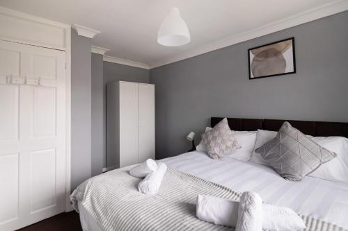 sypialnia z 2 łóżkami i białymi poduszkami w obiekcie The Kilnwood House w mieście Crawley