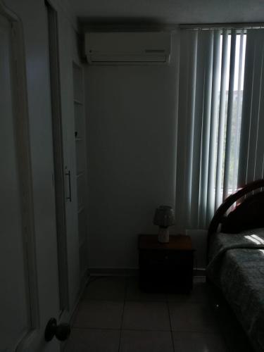 um quarto com uma cama e uma janela com cortinas em Arenys IV em Tonsupa