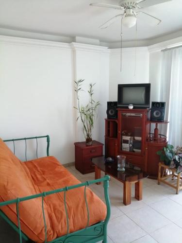 um quarto com uma cama, uma televisão e uma mesa em Arenys IV em Tonsupa