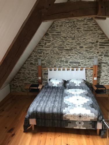 a bed in a room with a brick wall at La Longre in Cerisy-la-Forêt